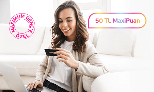 Koltukta oturan, kucağında bilgisayarı elinde kredi kartı ile internet alışverişi yapan genç kadın